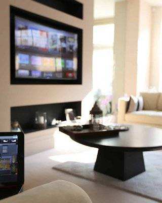 Control4 touchscreen controlling a living room TV and lighting