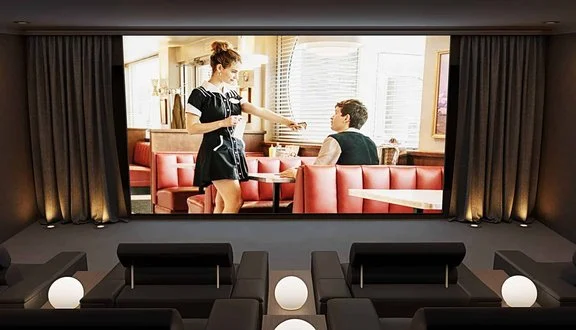Dedicated eight-seat home cinema room with acoustically transparent screen in Surrey